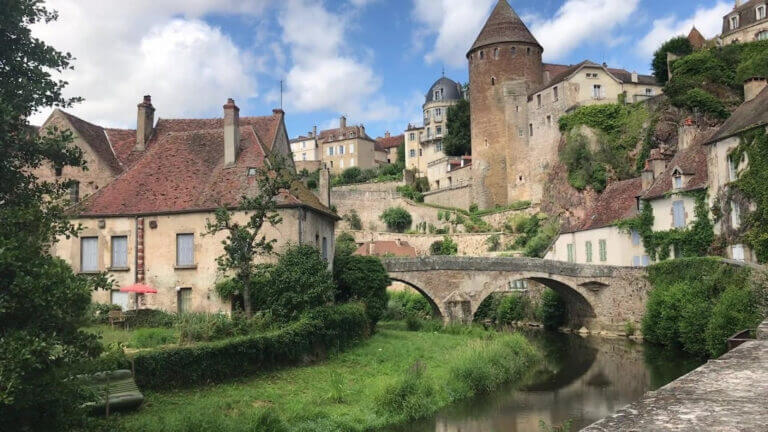 Une petite ville en France avec un pont sur une rivière.